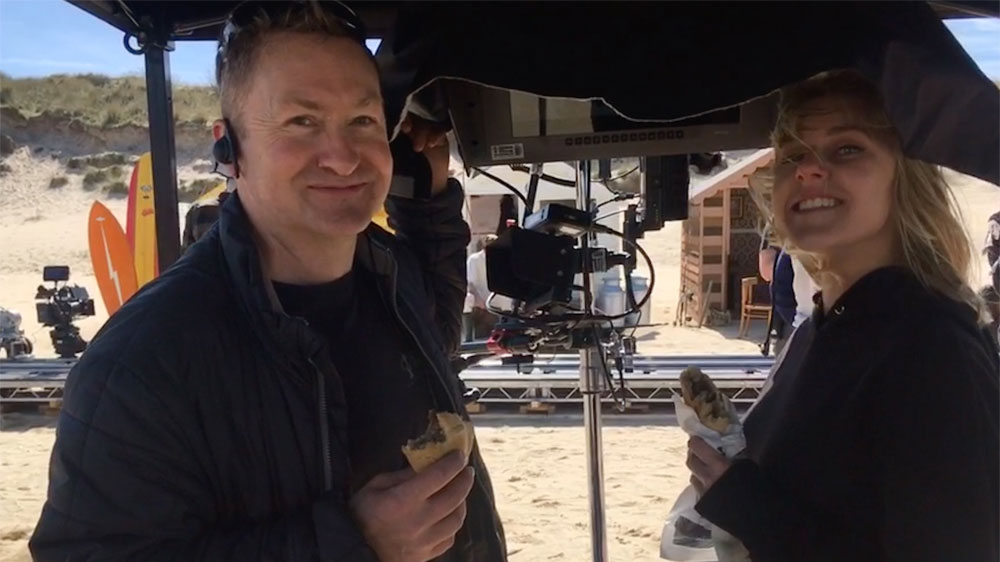 mark Brindle enjoying a Cornish Pasty on set of Kellys Cornish Icecream commercial featuring beach huts at Hayle Cornwall